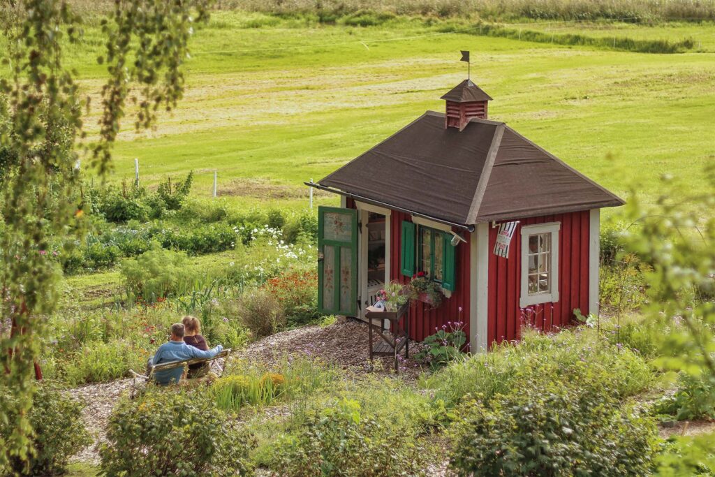 En bild på den lilla handelsboden mitt i den lummiga trädgården på Kulturodling i Lövsund
